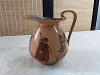 Side view of Royal Doulton ceramic pitcher showing Night Watchman figure and architectural drawings on beige body with curved handle.