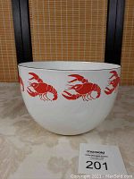 Front exterior view of the white enamel bowl showing red lobster pattern and black rim