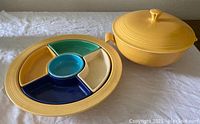 Front view of yellow Fiesta relish tray with multicolor removable sections and matching covered bowl