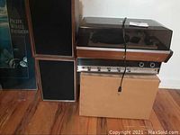 Photo shows the vintage Panasonic stereo receiver, turntable with plexiglass cover, and two wooden speakers stacked with one speaker lying horizontally.
