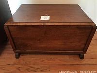 Front view of small wooden chest showing rectangular shape, finished wood, and sturdy legs.