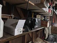 Photo showing Wilton Challenger bench grinder, Keiko Maintenance Kit box, plastic drawer storage organizer, and chemical bottles on a wooden shelf in garage