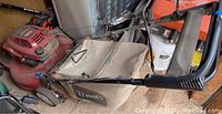 Photo showing the full Toro lawn mower with fabric grass catcher attached, visible on left side with branding on the bag.