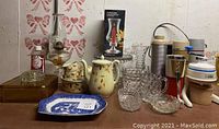 Wide view of vintage glassware, ceramic pieces, and thermoses with boxed candle stick