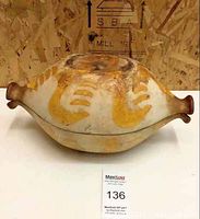 Front view of the vintage hand painted gourd with decorative yellow motifs and visible surface wear.