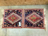 Photo of the entire rug laid flat showing two square pieces sewn together with fringe ends and multicolor geometric design