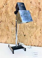 Front angle view of the vintage chrome adjustable desk lamp on light background.