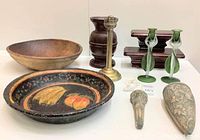 Full view of lot showing large wooden bowl, black painted bowl with fruit design, brass oil burner, wooden candlesticks, green glass vases, and carved decorative pieces