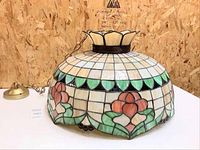 Photo of the large Tiffany style stained glass dome light fixture, showing the floral pattern and chain mount