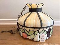 Full view of the Tiffany style stained glass hanging light fixture with chain visible, showing fruit motif and cream stained glass shade.