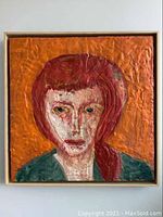 Frontal view of encaustic wax portrait with orange background, red hair figure and wooden frame.