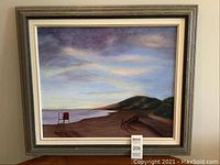 Front view of framed beach scene art showing lifeguard chair and coastline.