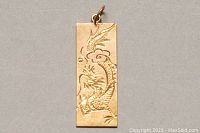 Front view of rectangular pendant showing dragon engraving