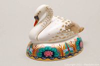 Photo of the bone china swan trinket box showing the side and top of the swan figure and colorful floral base.