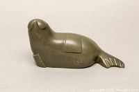 Side profile of the dark green soapstone walrus sculpture showing tail chip and rectangular detail on body