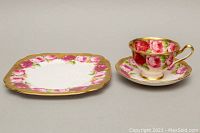 Photo showing the teacup, saucer, and luncheon plate with floral rose pattern and gold trim, arranged side by side.