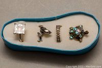 Four silver rings displayed in a light blue holder, showing various designs and wear.