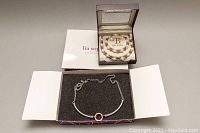 Bella Perlina freshwater pearl necklace, bracelet, and earrings set in original box, and Lia Sophia necklace in open box with foam insert.