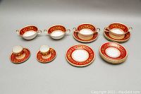 Full set overview showing all pieces including soup bowls, plates, and cups with saucers laid out.