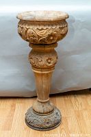 Front view of planter showing carved bowl top and pedestal base