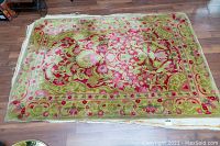 Full view of the hand hooked rug showing the floral design and overall condition on wooden floor.