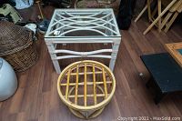 Two bamboo side tables on wood floor. One square painted white with glass top, one round natural bamboo without glass.