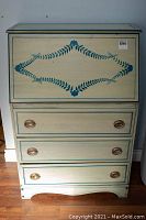 Front view of the secretary desk showing hand painted floral design and drawers