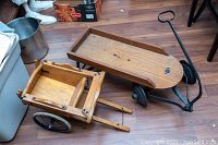 View of antique wooden children's wagon and cart on floor showing their overall shape and size.