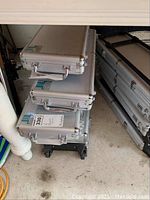 Stack of silver aluminum cases, three visible with ribbed exterior and latch handles