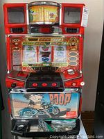 Front view of red plastic and metal slot machine with reels, push buttons, coin slot and Betty Boop artwork.