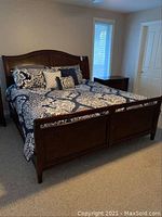 King-size bed frame assembled in bedroom with bedding in place