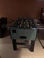 Front and side view of entire foosball table showing legs and exterior