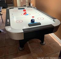 Table viewed from near corner showing playing surface with three pushers