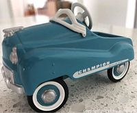 Blue 1955 Murray Champion miniature kiddie car with whitewall tires and Champion logo on side, detailed steering wheel and silver accents