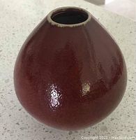 Maroon glazed, pear-shaped pottery reed diffuser vase with narrow opening