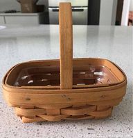Photo of Longaberger small basket with built-in handle, natural woven wood finish, and transparent protector inside.