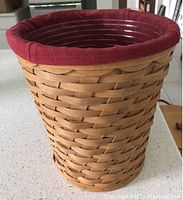 Tall scalloped wood basket with dark paprika fabric liner inside, protector visible at rim
