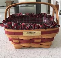 1993 Christmas Bayberry basket showing woven wood pattern with stained red accents, dual wooden handle, brass plaque, red plaid fabric liner with ruffles, and clear plastic protector inside.