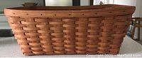 Extra large woven laundry basket in natural wood tones, rectangular shape, approx. 24x17x9 inches.
