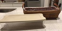Bread basket with fabric liner and snap-on lidded plastic protector on counter