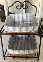 Photo of 2-tier wrought iron organizer stand with two lined baskets and clear plastic dividers inside baskets