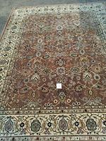 Full view of the large rectangular rug lying flat showing the overall design and border.