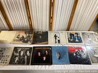 Full view of the 12 vinyl album covers on a table showing various classic rock bands.