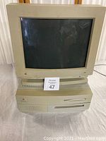 Front view of Apple Macintosh Centris 650 with CRT monitor on top, showing Apple rainbow logos and disk drive slot.