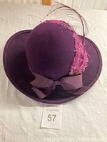 Purple wool felt hat with feather decoration and grosgrain ribbon bow