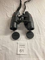 Front view of the Jason Perma Focus 2000 binoculars with lens caps removed, showing the large lenses and neck strap.
