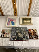 Five art and photography books arranged face up on white cloth, showing front covers.