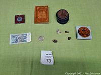 Full lot showing all coins, pins, banknote, and keepsakes displayed on green cloth.