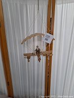 Ceiling hanging para sail with skeleton pilot, side view showing the wooden construction and suspension wires