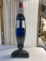 Front view of the Bissell cordless vacuum cleaner showing the blue and black body, Lift-Off feature, and upright design.